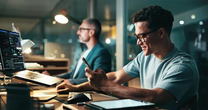 Programmer, man or excited in office with phone, project opportunity or code on laptop screen at night. Web development team, mobile or cheer in agency for deadline extension, incentive win or target