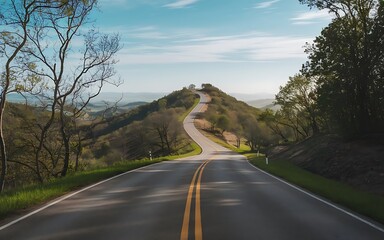 A photo of a winding road leading up a hill, with a view of the surrounding landscape.