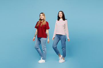 Fototapeta premium Full body young smiling happy cheerful couple two friends women wear red casual clothes together looking camera isolated on pastel plain light blue cyan background studio portrait. Lifestyle concept.