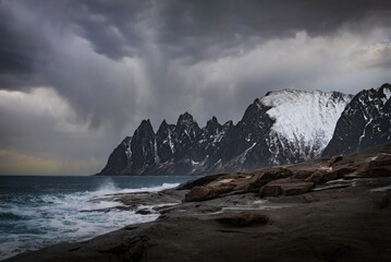 Landscape with breaking waves in front of the Devils Teeth on the Island of Senja in Northern Norway