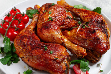 grilled fried chicken legs, served, with fresh cherry tomatoes, and herbs, on a white plate, homemade, no people,