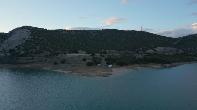Camper vans parked on a wild spot in Lake Polyfyto drone aerial view at sunset in Greece