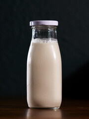 Milk juice bottle on wooden table with dark background