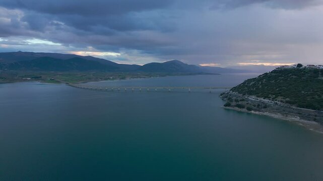 Lake Polyfyto mountain landscape and high bridge of Servia Neraida drone aerial view at sunset in Greece