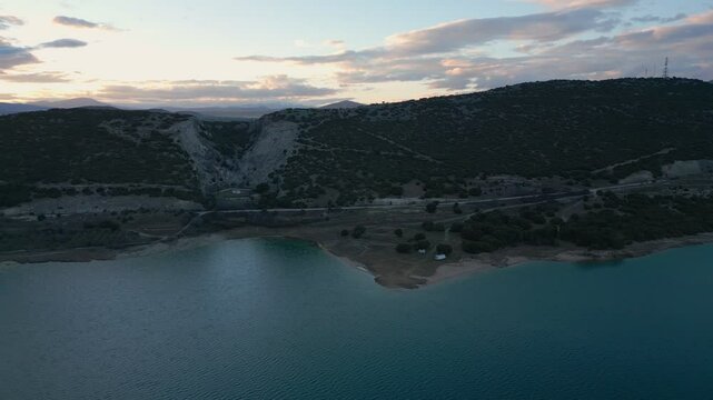 Camper vans parked on a wild spot in Lake Polyfyto drone aerial view at sunset in Greece