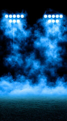 Stadium lights illuminate grass field obscured by fog; background blackness. Event use