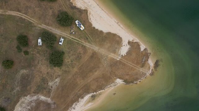 Camper vans parked on a wild spot in Lake Polyfyto drone aerial top view in Greece
