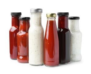 Different delicious sauces in glass bottles isolated on white