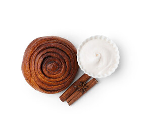 Tasty cinnamon roll with cream and sticks isolated on white, top view