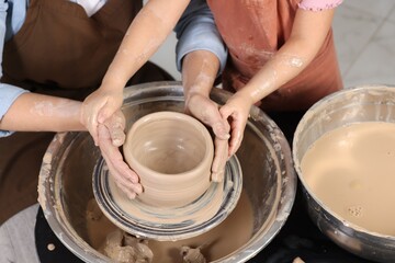 Hobby and craft. Mother with her daughter making pottery indoors, closeup