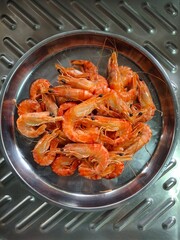 Cooked shrimp in a round stainless steel tray, shrimp in a pan