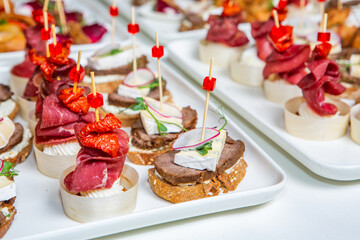 Catering buffet or service with different snacks, appetizers and canapes on a table. Variety of Freshly Prepared Catering Food for an Event.