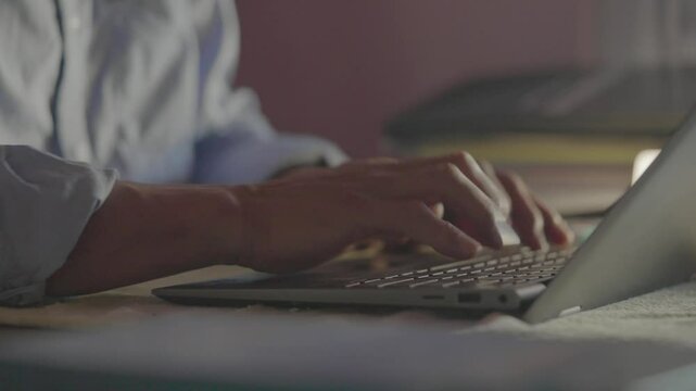 Young casual business man sitting on the chair and working on laptop, Man working on laptop, Remote work, journalist or entrepreneur working late at night, writing message in social network