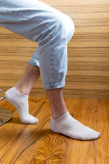 Men's legs in gray short socks on the background of the interior.