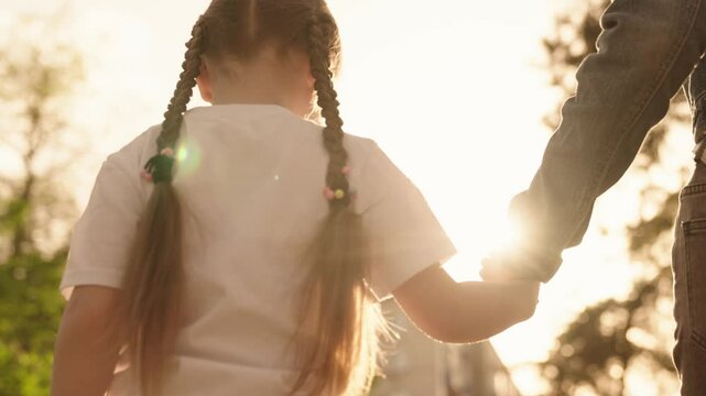 child hand mother close-up. mom holds hand little child kid walking park outdoors. chidhood dream. happy family. hand kid hand parent guardian rays sunlight. city walk child daughter. teamwork.