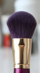 Close-up of purple makeup brush; gold ferrule; blurred background.  Perfect for beauty blogs and product websites
