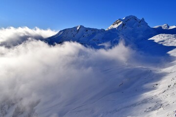 Panorama of snow covered mountains with blue sky and clouds. Winter season landscape and ski...