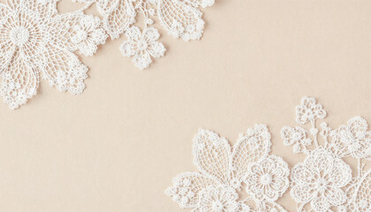 Un fondo texturizado que presenta intrincados motivos florales de encaje blanco sobre una superficie beige suave. El encaje tiene un diseño delicado