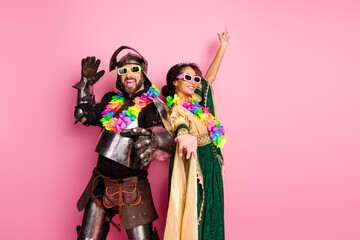 Fototapeta premium Elegant Couple in Retro Costumes Celebrating with Modern Accessories Against a Vibrant Pink Backdrop