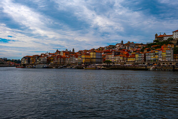Picture of the river in the foreground and the city on the riverbank in cloudy weather