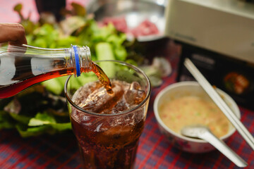 refreshing soft drink is poured over ice, fizzing in a glass perfectly complementing delicious meal...