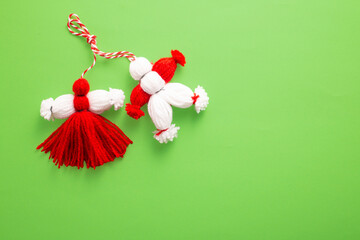  Traditional Martenitsa on green background. Baba Marta, greeting card. Flat lay