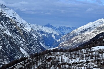 Panorama of snow covered mountains with blue sky and clouds. Winter season landscape and ski...