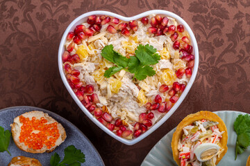 Salad with chicken and pineapple and pomegranate in a heart-shaped salad bowl