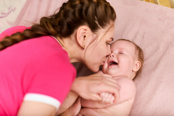 Mother kissing baby girl in warm, intimate moment
