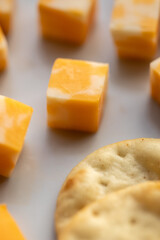 cubes of Colby Jack cheese on white plate with pita crackers