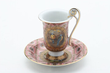 Delicate porcelain teacup displaying golden trim and perched blue tit birds, complementing elegant tea moments