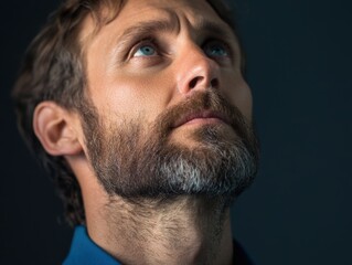 Obraz premium man looking up with beard in contemplative pose