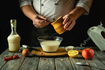 Hands of a dedicated cook expertly mix fresh ingredients in a rustic setup, showcasing a bowl filled with creamy concoction. Juicy fruits and creamy liquid await transformation into a delightful dish
