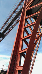 Close up view of the intricate steel framework of the transporter bridge, showcasing its engineering marvel against a clear blue sky