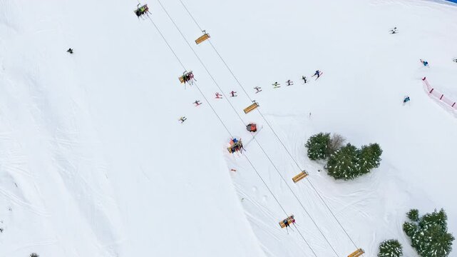 Aerial drone view of people having a ski lesson, at a ski resort in Corvara in Badia covered in snow, in South Tyrol, the Dolomites