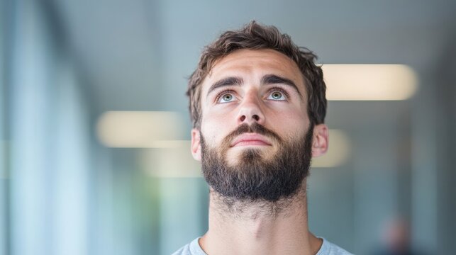man looking up in brightly lit hall