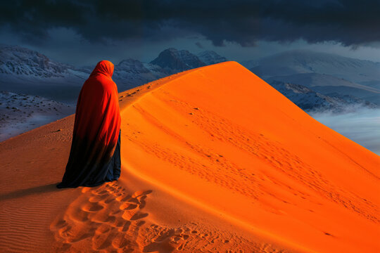 Hooded Figure on a Bright Orange Desert Dune