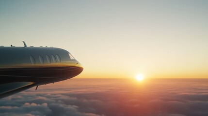 A breathtaking sunset can be seen from the wing of a private jet soaring high above the clouds. The vibrant sky showcases hues of orange and yellow while sun descends