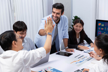 Happy office worker and project manager celebrate in meeting room after successfully achieving...