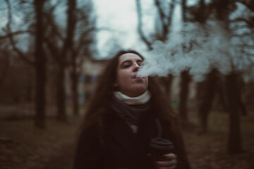 Fototapeta premium Woman smoking against dramatic landscape