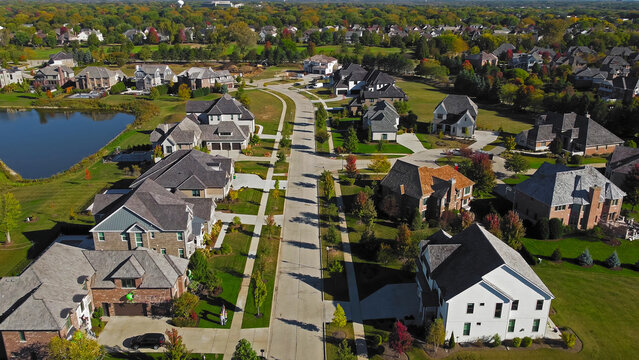 Aerial view of suburban neighborhood in Chicago, Illinois. A scenic aerial view of a suburban neighborhood in Chicago, Illinois, featuring large homes with manicured lawns.
