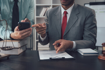 Legal Collaboration: Two legal professionals meticulously review a document, one pointing to a...