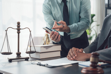 Legal Consultation: Two lawyers are engaged in a serious discussion, reviewing documents and using...