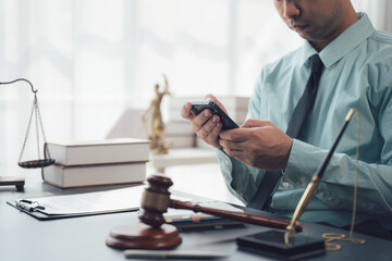 Lawyer using Smartphone in Office: A focused lawyer meticulously uses his smartphone, surrounded by...