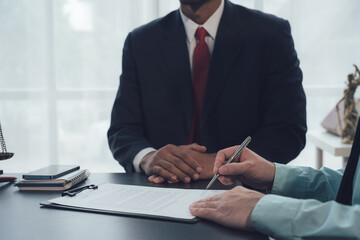 The Power of Signature: A closeup shot of a lawyer in a dark suit and red tie, with a client...