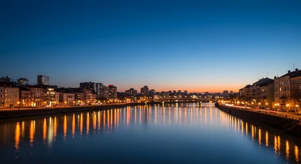 Obraz premium Cityscape at Dusk with River Reflection and Evening City Lights