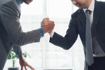 Business Arm Wrestle:  Two businessmen locked in an intense arm wrestle, symbolizing a fierce...