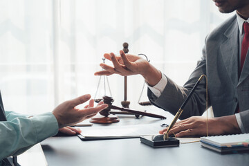 Legal Consultation: A lawyer gestures towards a scale of justice while discussing legal matters...