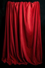 Deep red fabric curtain drapes elegantly against a dark background for theatrical effect and artistry