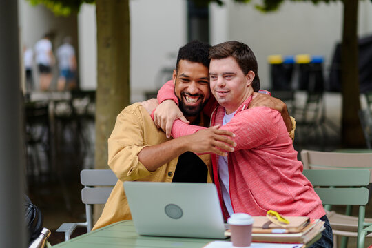 Young man with Down syndrome hugging his special educator teacher.